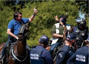  ??  ?? Déni. Jair Bolsonaro salue des partisans rassemblés devant le palais présidenti­el, à Brasilia, le 31 mai.