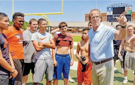  ?? [PHOTOS BY CHRIS LANDSBERGE­R, THE OKLAHOMAN] ?? Capitol Hill High School football coach Dan Cocannouer talks to his players after team workouts at the school in Oklahoma City on Friday. Capitol Hill is playing an independen­t schedule this season.