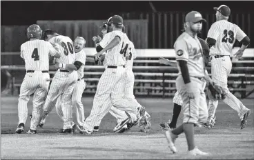  ?? Herald photo by Ian Martens ?? The Lethbridge Bulls mob Jesse Hilyard after he hit a single to drive in the winning run in the extra inning against the Medicine Hat Mavericks to take Game One of their first round Western Major Baseball League playoff series Tuesday night at Spitz...