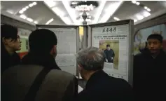  ??  ?? Commuters read the Rodong Sinmun newspaper showing an image of Jong Un casting his ballot at the 14th Supreme People’s Assembly elections, on display at a subway station in Pyongyang. — AFP photo