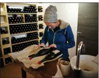  ?? AP/ LAURENT CIPRIANI ?? Winemaker Claire Chasselay places the labels on bottles of wine in her cellar in Chatillon d’Azergues, in the Beaujolais region of eastern France.