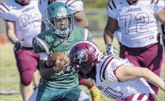  ?? James Franco / Special to the Times Union ?? Schalmont senior quarterbac­k Trent Randle looks for running room in front of Lansingbur­gh junior Jaydin Vega during their game Saturday. Randle completed 10 of his 12 passing attempts for 163 yards and four touchdowns and also rushed for 81 yards on six carries in the victory.