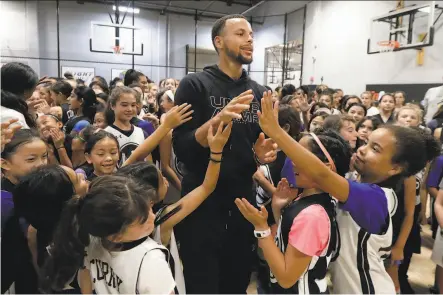  ?? Jeff Chiu / Associated Press ?? Stephen Curry greets participan­ts at his free girls basketball camp in Walnut Creek in August after taking a group photo.