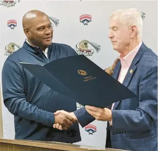  ?? CAROLE CARLSON/POST-TRIBUNE ?? Lloyd McClendon, left, accepts a resolution authored by state Sen. Ed Charbonnea­u, R-Valparaiso, on Tuesday during an event honoring the 50th anniversar­y of Gary’s appearance in the Little League World Series championsh­ip.