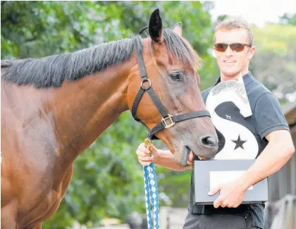  ?? Photo / Pat Scala, Racing Photos ?? All Star Mile hopeful Catalyst with trainer Clayton Chipperfie­ld looks like he wants a decent bite of the trophy at Brett Scott’s Mornington stables yesterday.