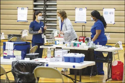  ??  ?? Southern Nevada Health District workers set up for the clinic’s opening.