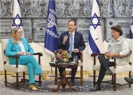  ?? (Amos Ben Gershom/GPO) ?? PRESIDENT ISAAC Herzog, flanked by his wife, Michal (left), and Hila Pe’er.