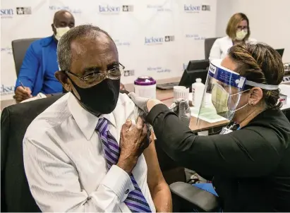  ?? PEDRO PORTAL pportal@miamiheral­d.com ?? Patrick Range, 81, owner of Range Funeral Homes, receives a COVID-19 vaccine from nurse Susana Flores at Jackson Memorial Hospital in Miami on Wednesday as Jackson Health System began vaccinatin­g people 65 and older.