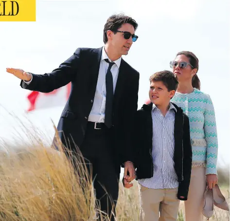  ?? CHARLY TRIBALLEAU / AFP / GETTY IMAGES ?? Prime Minister Justin Trudeau speaks to his wife Sophie Gregoire and son Xavier as they walk along Juno Beach in Courseulle­s-sur-Mer, France. The prime minister told a news conference during the visit that the way forward in Syria can’t include...