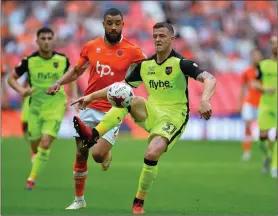  ??  ?? Pierce Sweeney of Exeter City clears from Kyle Vassell of Blackpool during the Sky Bet League Two Play-off Final at Wembley.