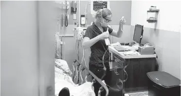  ?? DAMIAN DOVARGANES/AP ?? Nurse Sandra Younan sets up a new intravenou­s line last week at Providence Cedars-Sinai Tarzana Medical Center in Los Angeles.