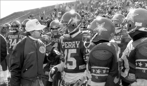  ?? Associated Press ?? Perry coach Gus Catanese talks with his players during the 1989 PIAA Class AAA championsh­ip against Berwick at Hersheypar­k Stadium. Perry won the title that year and is still the only City League team to win a state football championsh­ip.