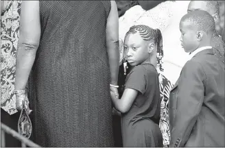  ?? PHOTOS By yALONDA M. JAMES/THE COMMERCIAL APPEAL ?? Mya Weathersby, 7, a second-grade student at Cummings Elementary, waits to enter Metropolit­an Missionary Baptist Church Friday for the funerals of four of her schoolmate­s.