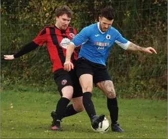  ??  ?? Glen Hughes of Courtown Hibs is challenged by Jonathan Savage of Gorey Rangers.