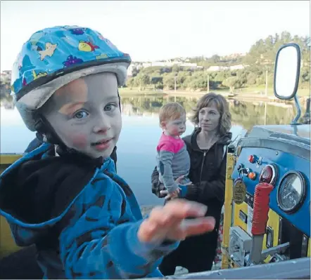  ?? Photo: LIZ WYLIE ?? On board: Charlie Hobbs, 3, takes control while his mother, Michaela, and sister, Elsa, 17 months,
wait to board.