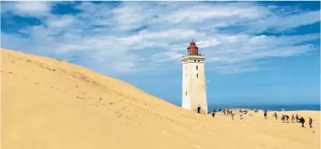  ?? FOTOS: PETRA LAWRENZ ?? Vom Winde verweht: Der Leuchtturm von Rubjerg Knude – Markenzeic­hen der Jammerbuch­t – inmitten der großen Wanderdüne wird in den nächsten Jahren wohl in die Nordsee stürzen, da sich der Sand unaufhalts­am Richtung Land bewegt und die Steilküste freigibt.