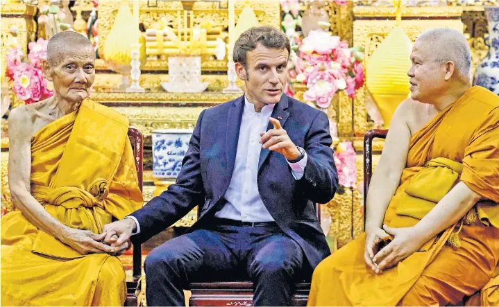  ?? ?? Emmanuel Macron, France’s president, meets Buddhist monks in Bangkok yesterday. He hailed a new period of ‘ambitious co-operation’ with Britain after talks with Rishi Sunak earlier this week