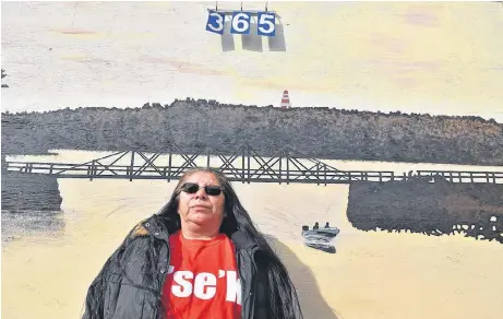  ?? BRENDAN AHERN/THE NEWS ?? Pictou Landing First Nation artist Cheryl Denny standing in front of her finished mural with the countdown calendar fastened to it.