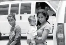  ?? ASSOCIATED PRESS ?? A MOTHER MIGRATING FROM HONDURAS holds her 1-year-old child as she surrenders to U.S. Border Patrol agents after illegally crossing the border Monday near McAllen, Texas.