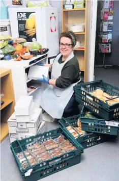  ??  ?? Grateful Heather Kay helps to sort some of the food that has been donated to the Star Project