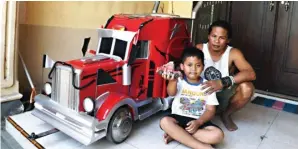  ?? MOCH. DIDIN SAPUTRO/JAWA POS RADAR KEDIRI ?? KREATIF: M. Irfansyahr­oni bersama putranya di samping salah satu miniatur truk karyanya.