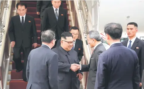  ??  ?? Balakrishn­an welcomes Kim on his arrival in Singapore. — Reuters photos