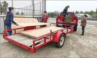  ?? CLAUDIA ELLIOTT / FOR TEHACHAPI NEWS ?? Tehachapi Mountain Roller Hockey players unload plywood needed to restore the rink on Tehachapi Boulevard near Coy Burnett Stadium on May 7.