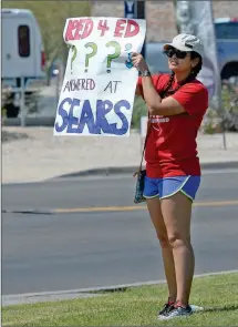  ??  ?? LEFT: PARTICIPAN­TS IN TUESDAY’S #REDFORED demonstrat­ion wave at motorists on eastbound 32nd Street at the Big Curve. ABOVE: Ana Ortega, a first-grade teacher at J.W. McGraw Elementary School, holds up a sign along 32nd Street during Tuesday’s #RedForEd...