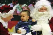  ?? MARK THIESSEN — THE ASSOCIATED PRESS ?? This photo shows Nate Pete sitting on Santa Claus’ lap in Saint Michael, Alaska, a remote island community off the state’s western coast in the Bering Strait.