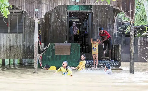  ?? ?? Water woes: Children playing in floodwater­s at Kampung Buluh in Terengganu. nadma reported that the number of flood victims in Terengganu, Kelantan and Pahang dropped to 1,604 people at 17 PPS as at 4pm yesterday, compared to 2,626 victims at 31 PPS at noon. — Bernama