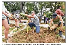  ?? HYOSUB SHIN/HSHIN@AJC.COM ?? Cory Mosser (center), founder of Natural Born Tillers, works with volunteers at the Officer Edgar Flores Memorial Garden in Sara J. Gonzalez Memorial Park in Atlanta.