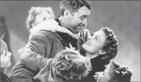  ?? Associatd Press ?? Child actor Karolyn Grimes on the back of Jimmy Stewart in a scene from the holiday classic “It’s a Wonderful Life,” also starring Donna Reed.