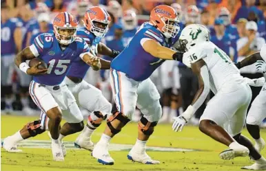  ?? JOHN RAOUX/ AP ?? Florida quarterbac­k Anthony Richardson (15) looks for running room as South Florida defensive end Eddie Kelly (16) looks to stop him. Richardson tossed two more intercepti­ons and now had four on the season.