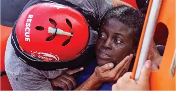  ??  ?? Ordeal is over: A rescue worker helps the terrified woman found in wreckage