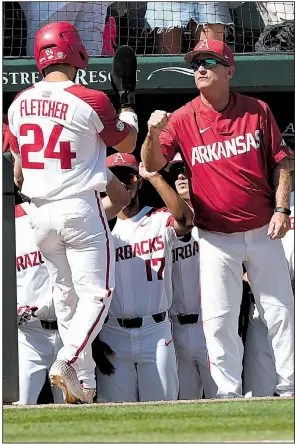  ?? NWA Democrat-Gazette/J.T. WAMPLER ?? Arkansas Coach Dave Van Horn (right) congratula­tes Dominic Fletcher after he scored during the Razorbacks’ 14-1 victory over Ole Miss in Monday’s final game of the NCAA Fayettevil­le Super Regional at Baum-Walker Stadium. Arkansas opens play in the College World Series at Omaha, Neb., on Saturday against Florida State. Complete CWS schedule, Page 5C.