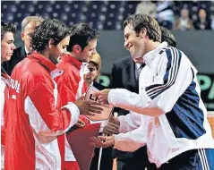  ??  ?? Davis Cup foes: Greg Rusedski shakes hands with Roger Federer in Geneva in 2005