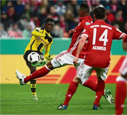 ??  ?? Bend it: Ousmane Dembele scoring Borussia Dortmund’s winning goal against Bayern Munich in the German Cup semi-final at the Allianz Arena on Wednesday. — Reuters
