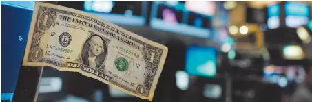  ?? AP FILE PHOTO ?? A dollar bill is taped to a trader’s computer screen at the New York Stock Exchange in Dec. 2016. The good times keep rolling for fund investors. As of late June 2017, nearly every type of fund logged gains over the three months prior, with technology...