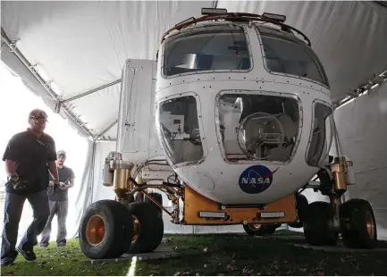  ?? Yi Chin Lee / Houston Chronicle ?? NASA crew members direct the placement of a Space Exploratio­n Vehicle onto its exhibit site Monday at Discovery Green.