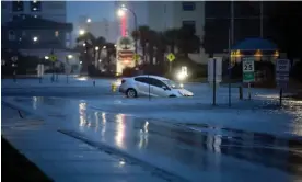  ?? Photograph: Jason Lee/AP ?? A car plunged into flood waters on Ocean Boulevard in North Myrtle Beach, South Carolina, on Wednesday after the passage of Hurricane Idalia.