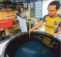  ?? [FOTO LUQMAN HAKIM ZUBIR /BH] ?? Pengusaha restoran menyimpan bekalan air sebagai persiapan di Taman Puncak Jalil.