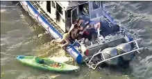  ??  ?? RESCUE: An woman is pulled aboard an NYPD boat Tuesday after a ferry hit two kayaks and overturned eight others.