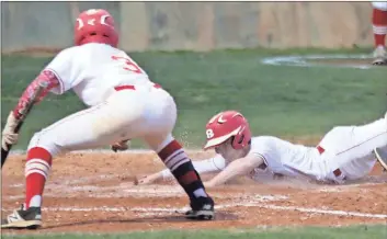  ?? Tommy Romanach / Rome News-Tribune ?? Rome High’s Kade Garrard (right) slides home to score the winning run as teammate Jakolbi Griffin (3) waits to celebrate with him during the Wolves’ 5-4 victory Wednesday against Woodland at Legion Field.