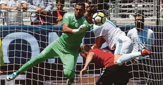  ??  ?? Aksi Bale (kanan) mengasak penjaga gol Manchester United, Sergio Romero pada saingan Piala Kejuaraan Antarabang­sa di California.