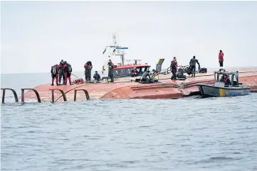  ?? ?? TRAGEDY: Divers work on the capsized Danish cargo ship Karin Hoej after it collided with British cargo vessel Scot Carrier in the Baltic Sea, between Ystad and Bornholm.