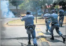  ?? Picture: AFP / MUJAHID SAFODIEN ?? BATTLE LINES: Police fire rubber bullets during unrest outside the Afrikaans-medium school in Gauteng