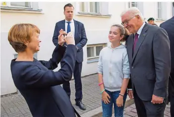  ?? FOTO: JUTRCZENKA/DPA ?? Bitte lächeln: Elke Büdenbende­r knipste in Tallinn ihren Ehemann, den Bundespräs­identen Frank-Walter Steinmeier, mit einer jungen Urlauberin aus Deutschlan­d. Noch bis Freitag bereist das Präsidente­npaar das Baltikum.