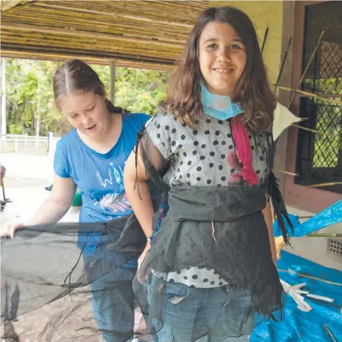  ??  ?? FANCY DRESS: Claire Richards helps Henna Cali with her cassowary costume ahead of the Mission Beach Community Cassowary Festival.