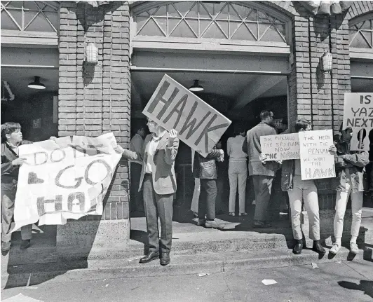  ??  ?? Red Sox fans bearing placards picket outside Fenway Park on April 20, 1969, to protest Hawk Harrelson’s trade to the Indians.