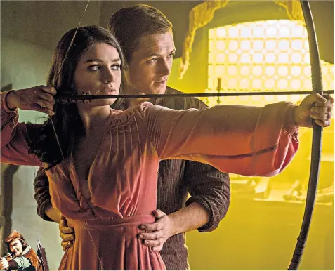  ??  ?? English outlaw Robin Hood is played by British actor Taron Egerton, above left, with Jamie Foxx (Little John) and, above, with Eve Hewson, the Irish actress and daughter of Bono, who takes the part of Maid Marian